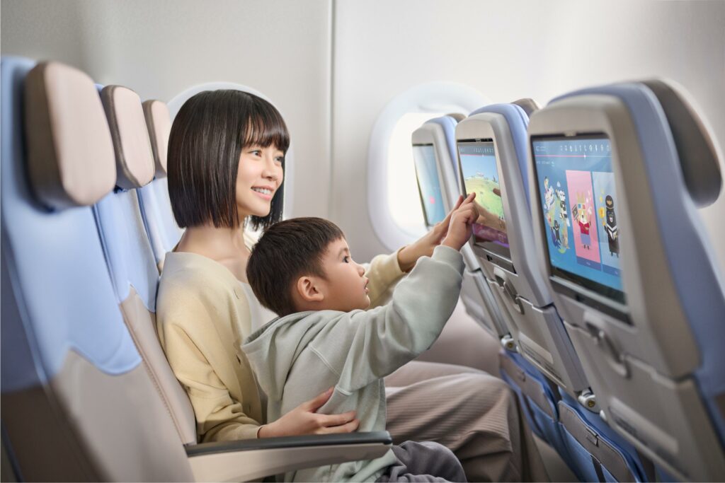 Asian mother and child are interacting with FlightPath3D on the seatback entertainment for China Airlines