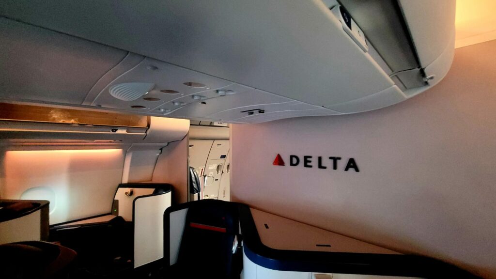 Delta's cabin branding element in business class, with orange mood lighting setting a calm environment