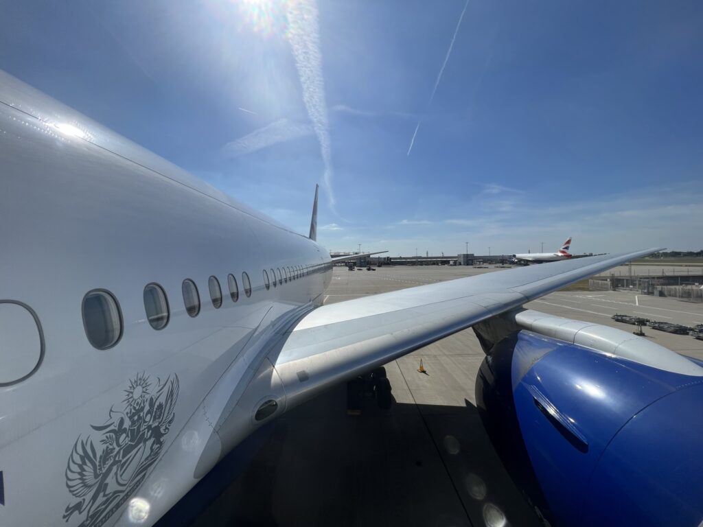 The BA 777 parked at the gate on a sunny day