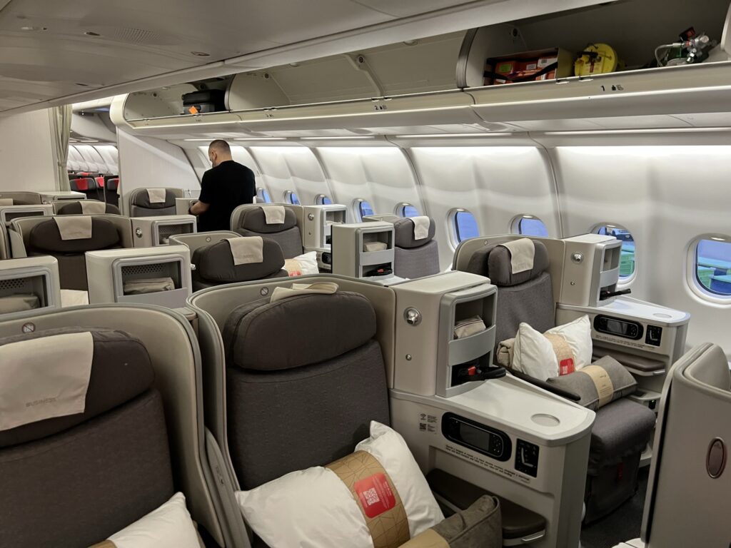 Iberia A330-200 business class cabin. Each seat is all grey with a white pillow and grey blanket sitting on top.