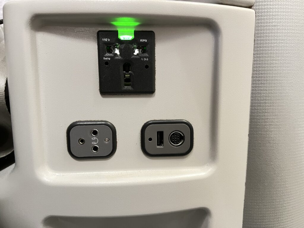 USB and AC power outlets in the Iberia A330-200 business class seat.