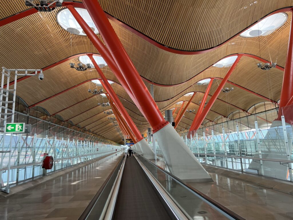 A photo of a nearly empty Madrid Airport with the facility's signature curved ceiling in full view