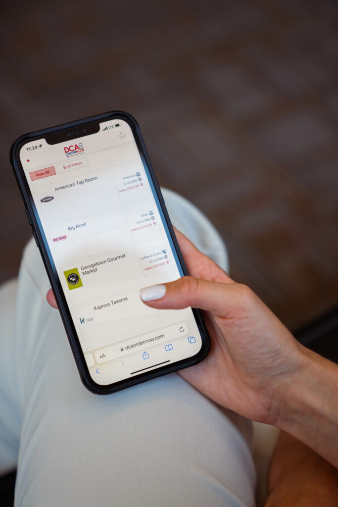 a passenger is ordering food in the airport via their mobile device