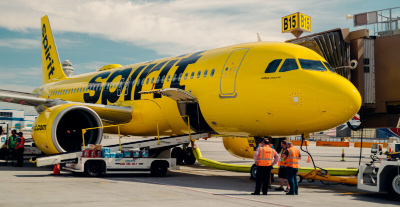 Spirit Airlines aircraft parked at the gate with the luggage door open for loading.