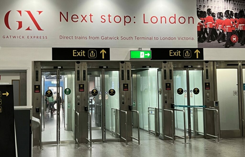 A large sign over the Gatwick Express entryway says "Next Stop: London"