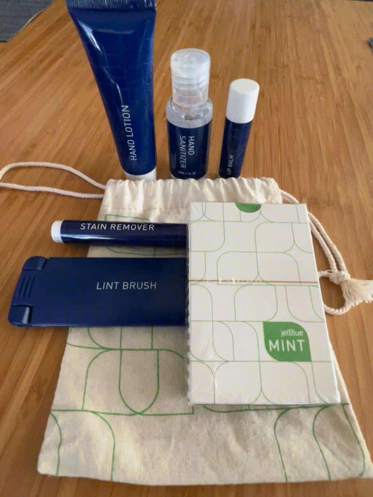 Contents of the JetBlue amenity kit. with creams, a satchel and other items all in blue. 