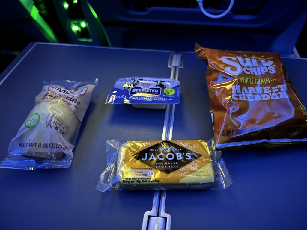 Various snacks displayed on a Delta aircraft tray table. 