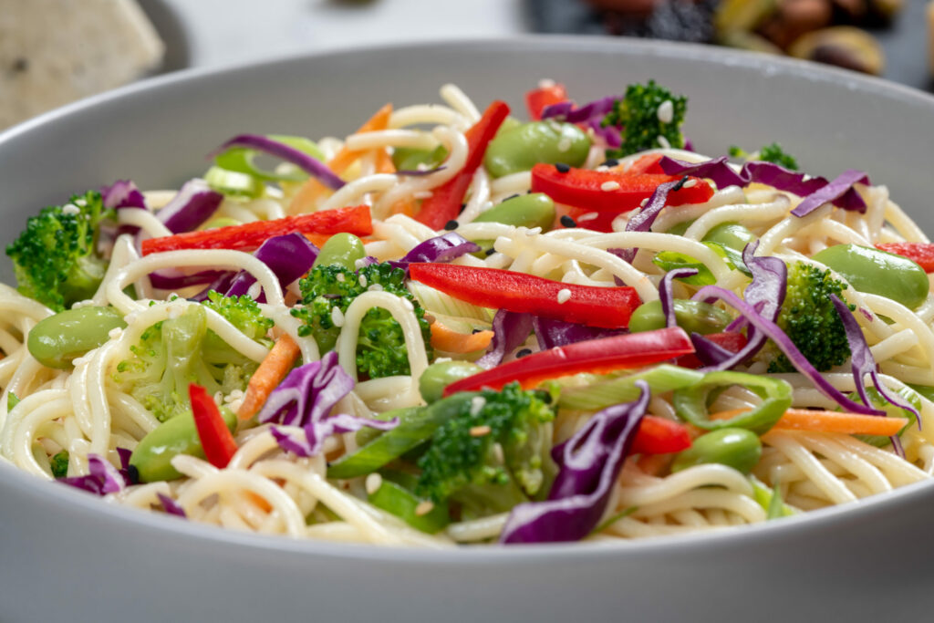 A noodle dish with a variety of vegetables on top