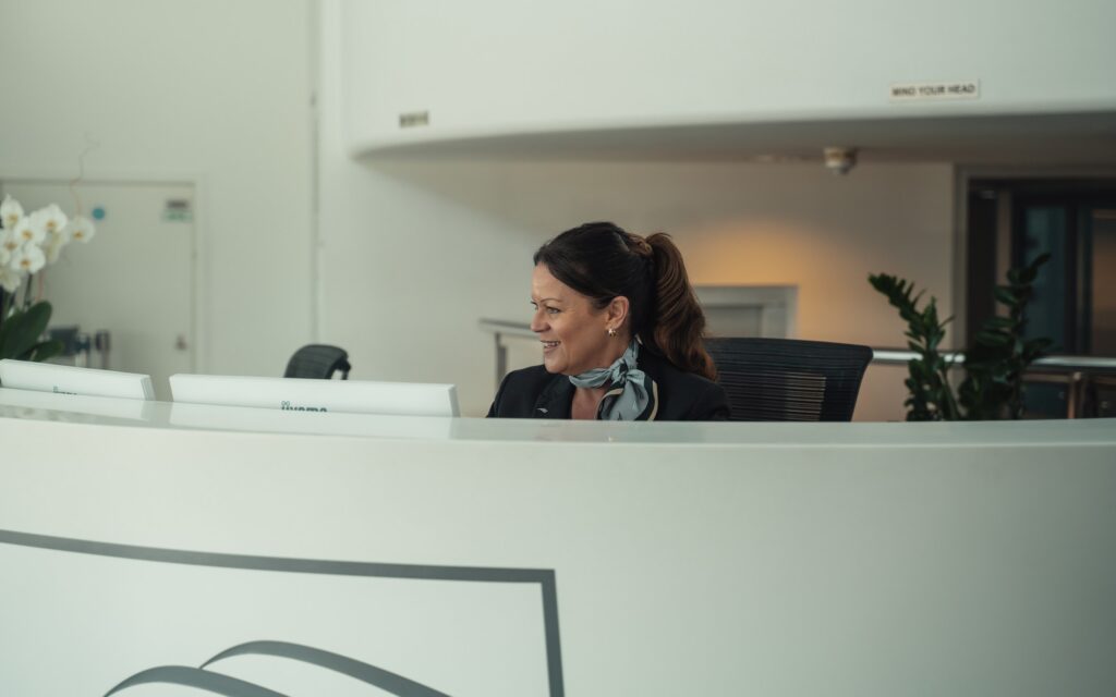 A woman is sitting behind a counter at Farnborough Airport