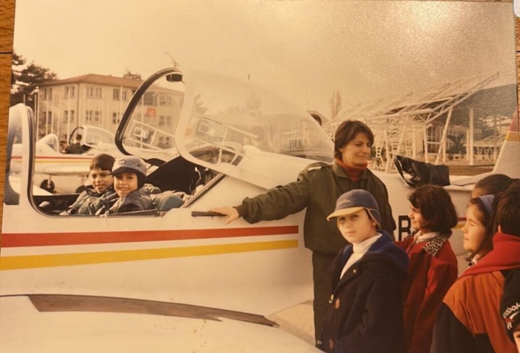 Doğan showing children around an aircraft. Two kids sit in the cockpit.