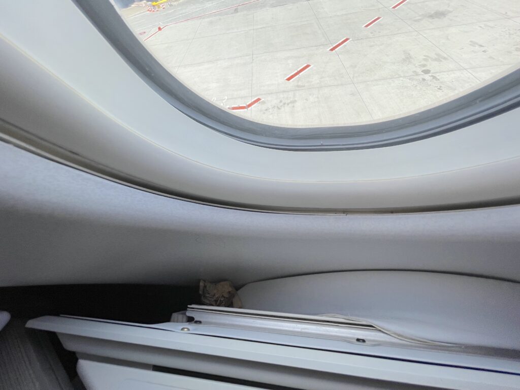 A close up showing some damage to the Air Canada A330 business class seat near the window.