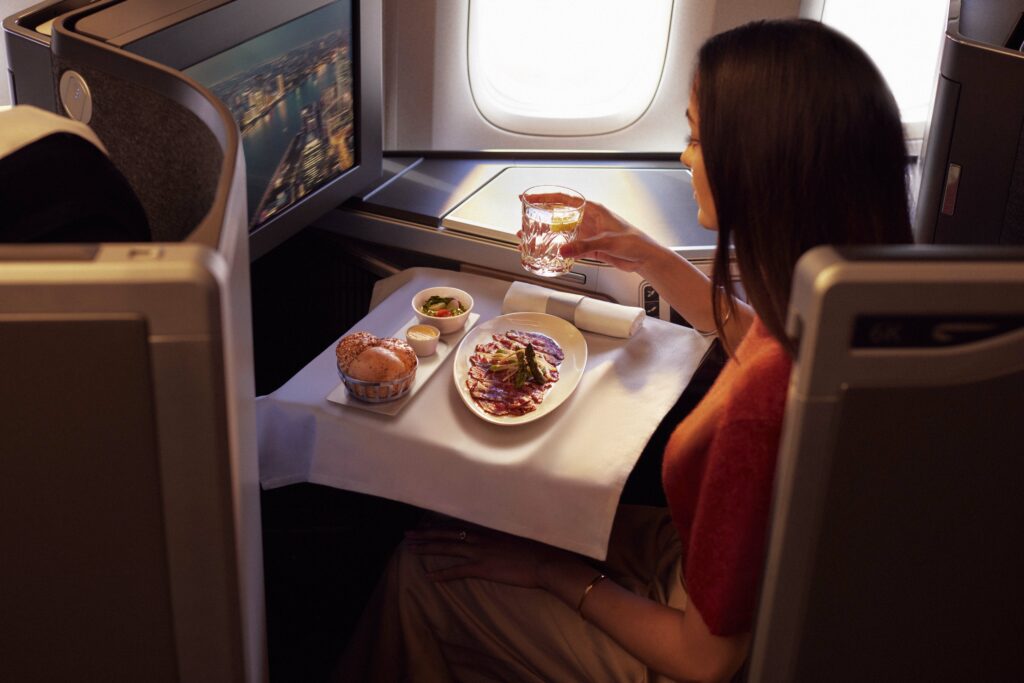 A woman is eating a British Airways meal inflight in a Club World Seat. (2)