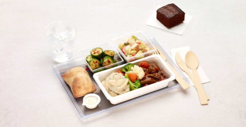 Air Canada Meal is being displayed with wooden cutlery on a white table.