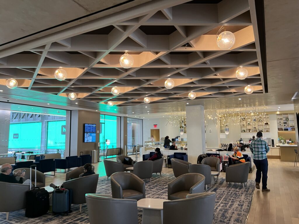 Amtrak Metropolitan/ lounge in Moynihan Train Hall has high decorative ceilings with various seating options.