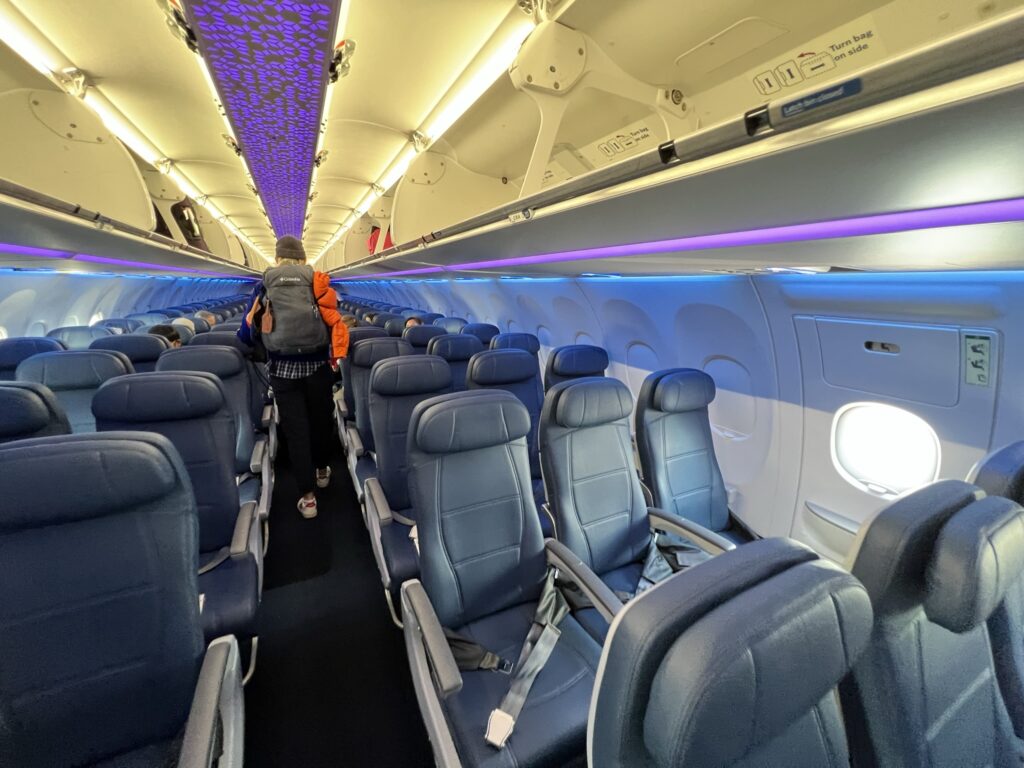 Purple and blue LED lights color the interior of the Delta A321neo cabin