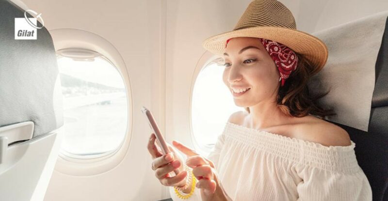 A woman is looking at her mobile device while on an aircraft. Image: Gilat