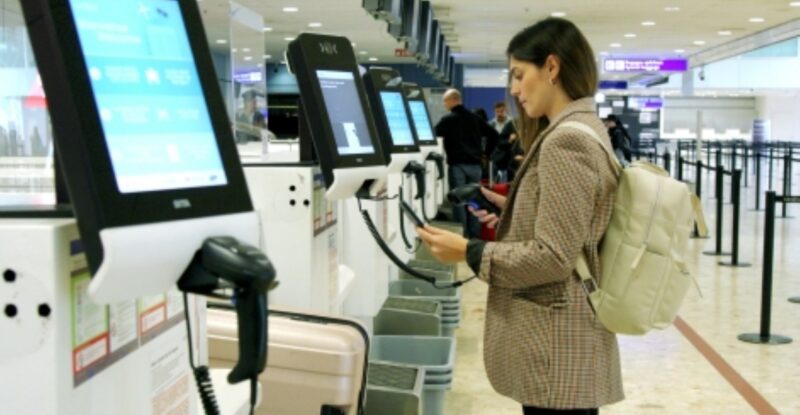 A passenger is standing at the SITA kiosk in Geneva Airport.