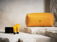 Air Canada Acqua di Parma Amenity Kit is displayed on rocks. The kit is a peachy orange colour.