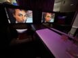 Large IFE screens show a mans face in the suite.