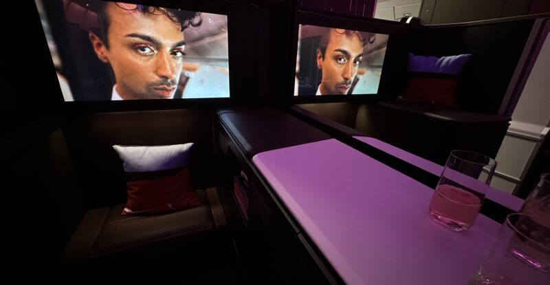 Large IFE screens show a mans face in the suite.