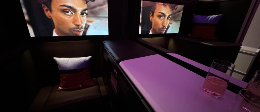 Large IFE screens show a mans face in the suite.