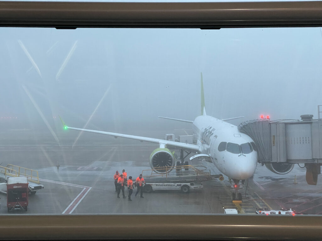 airBaltic aircraft at the gate on a foggy morning.