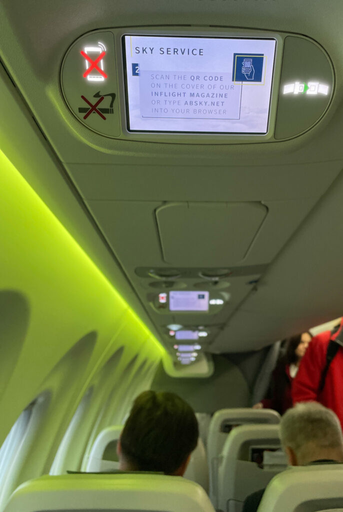 The overhead screen on airBaltic is showing a Sky Service announcement.