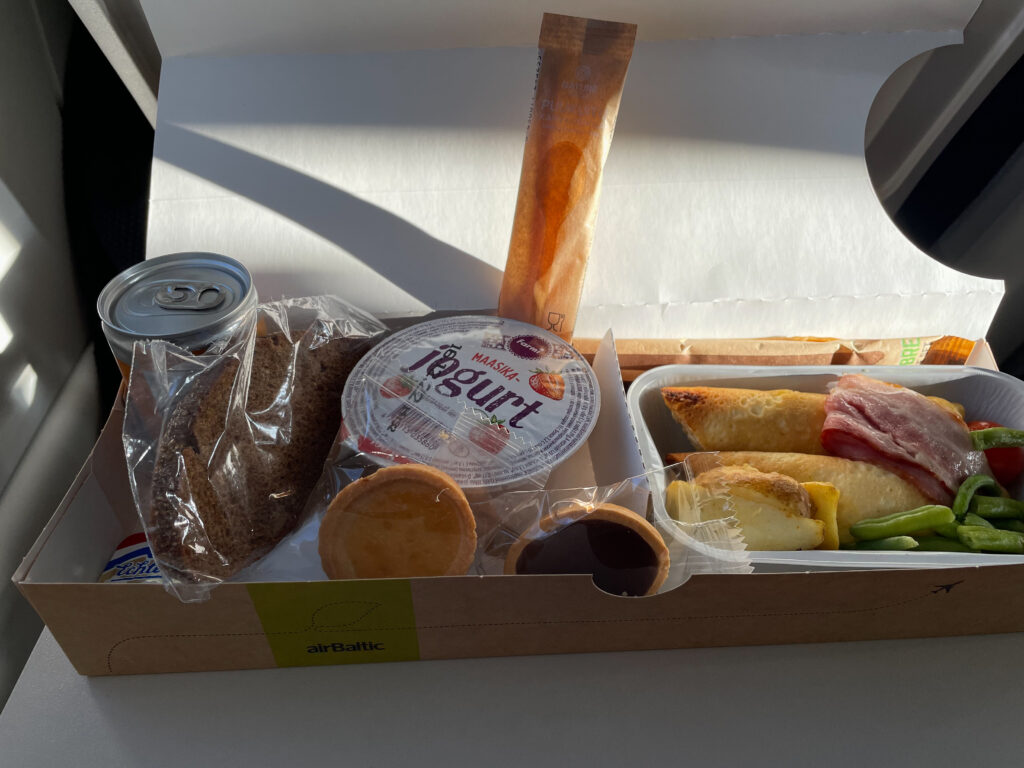 A larger view of the inflight food offering shows a hot breakfast, yogurt, cookies and a drink.