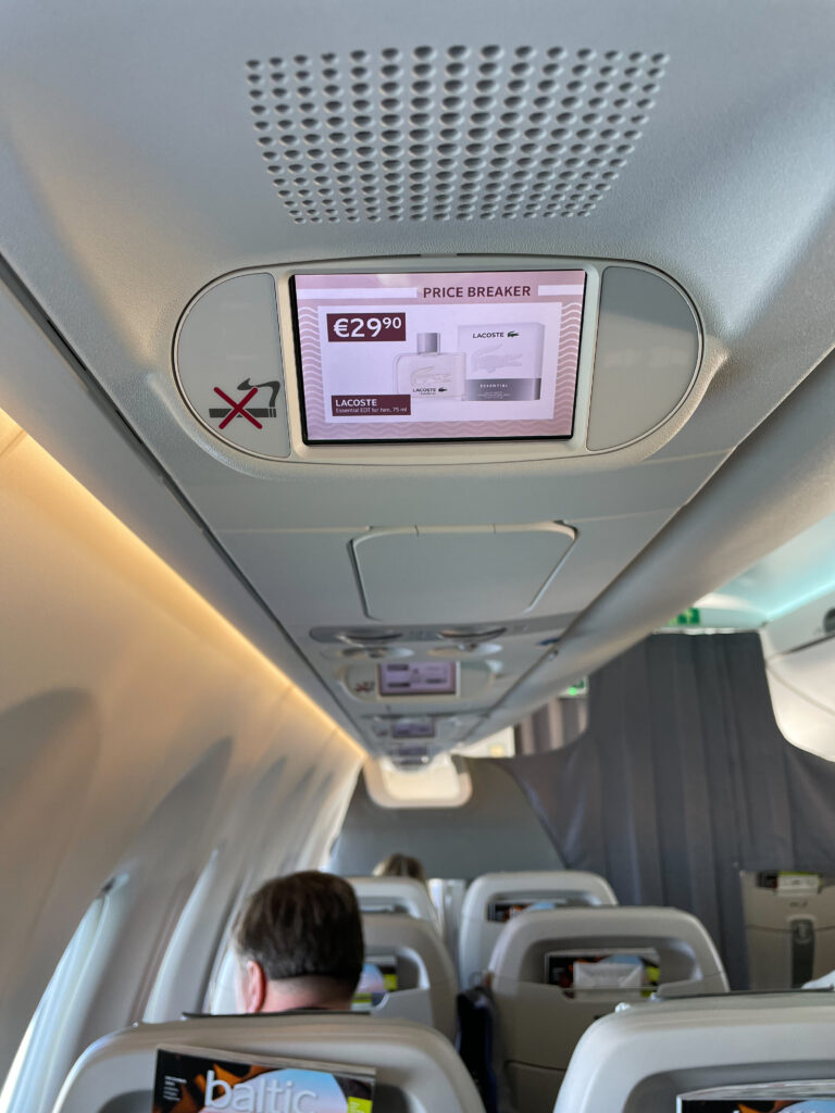 Overhead screen with a fragrance advertisement.