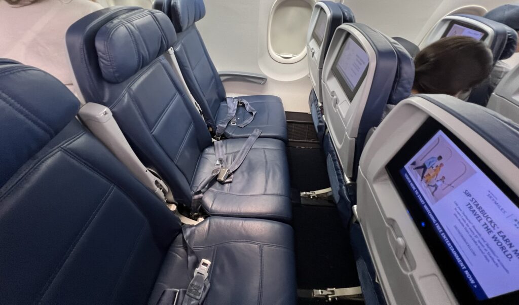 An economy class seat triple onboard the Delta Boeing 757.