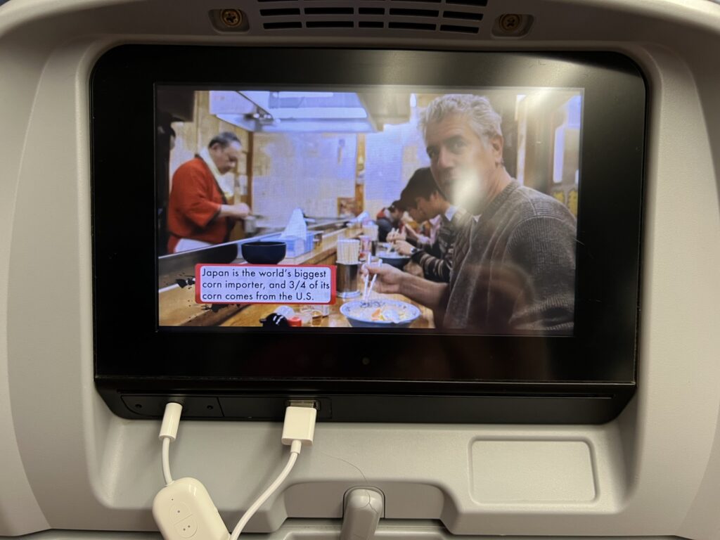 A clear IFE screen in front of the author, who is availing of the system's USB power port.