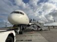 Passengers board a Delta 757 via stairs.