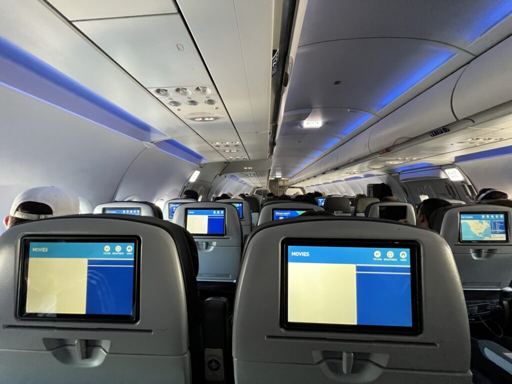 A photo snapped from aft of the JetBlue cabin, showing seatback IFE screens in economy class seats