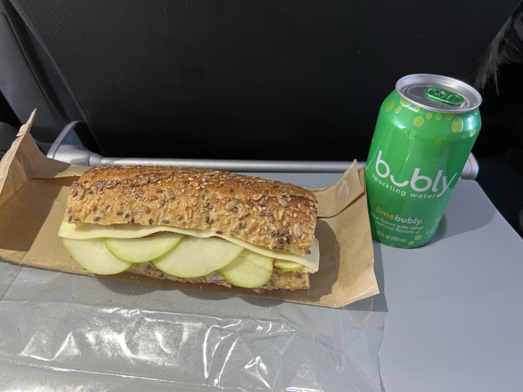 Turkey and apple sandwich next to a lime Bubly drink. 