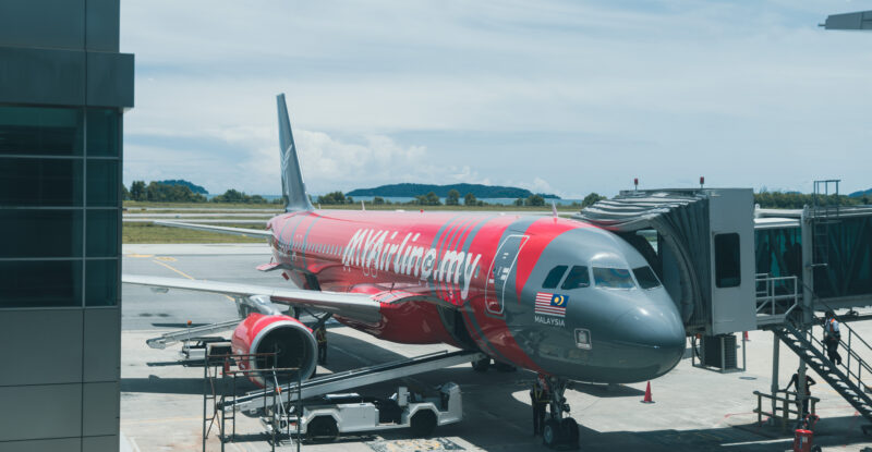 MYAirline aircraft parked at the gate. The livery is dark grey with red detailing.