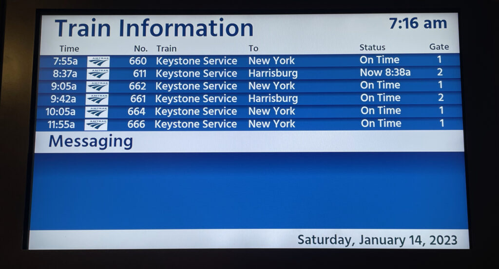 An Amtrak digital monitor with all departures listed.