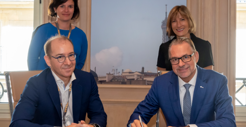 European Space Agency Joins Forces with Euroconsult. Two men are signing a document and two women stand behind them.