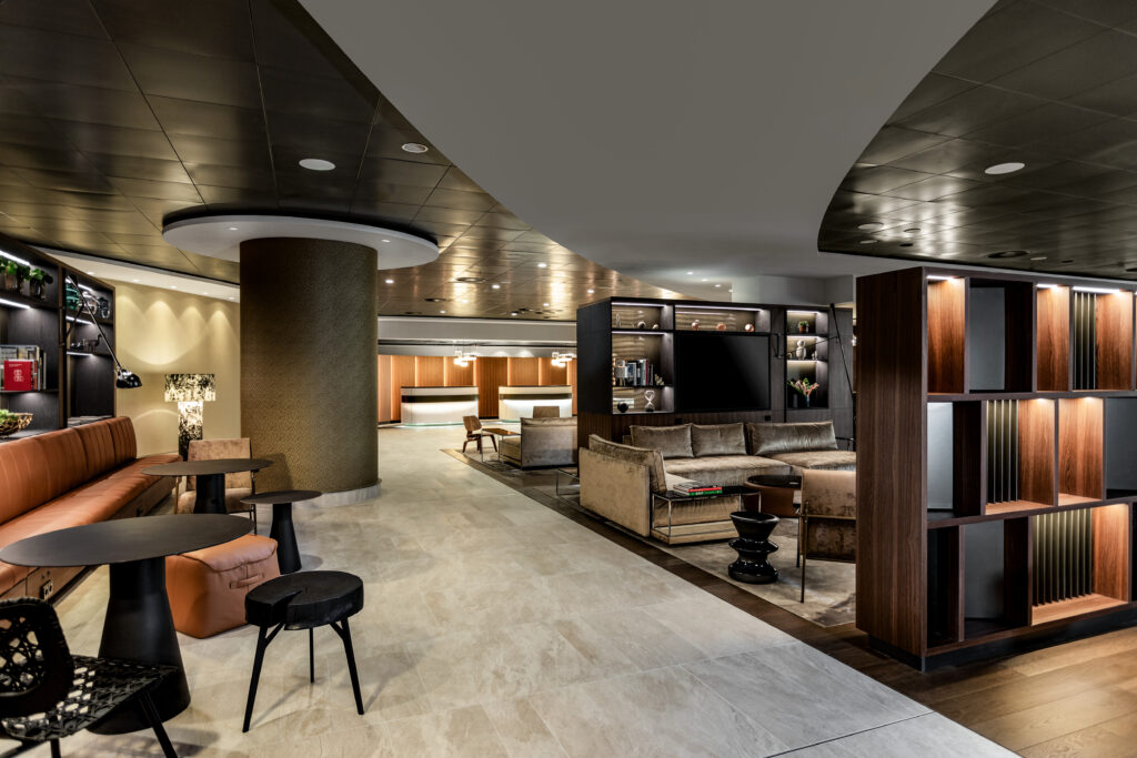 Large hotel lobby area with various seating options available. Dark brown and rust materials color the scene. 