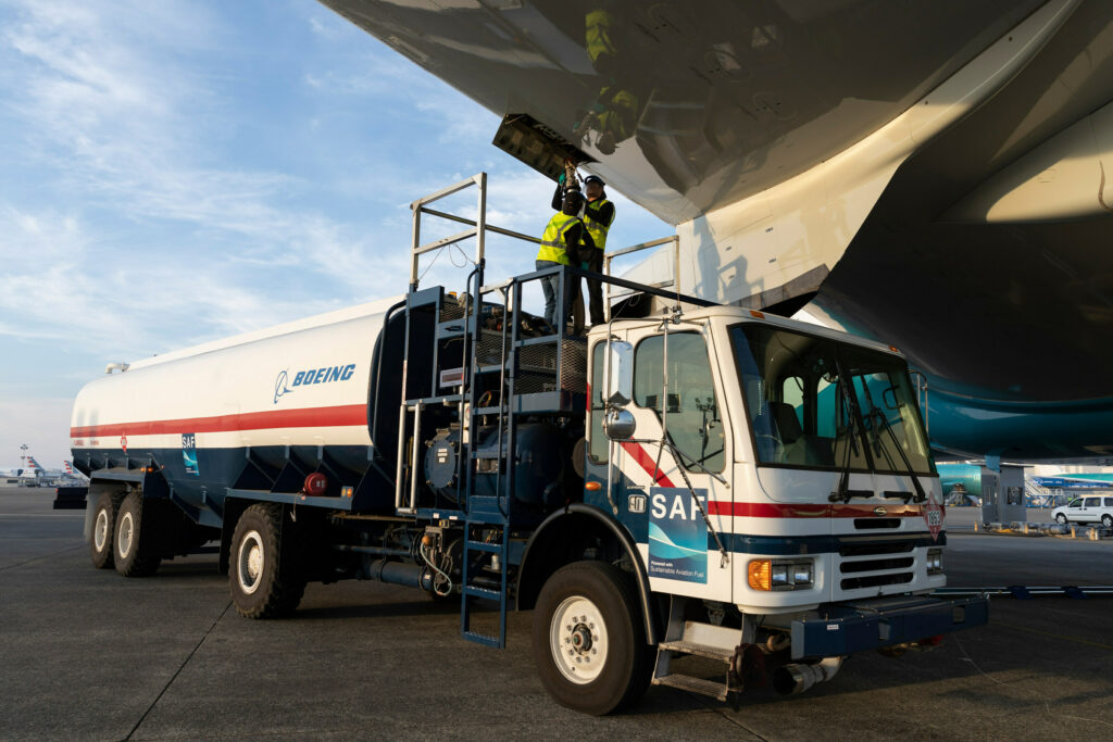 A Boeing sustainable aviation fuel truck is servicing an aircraft.