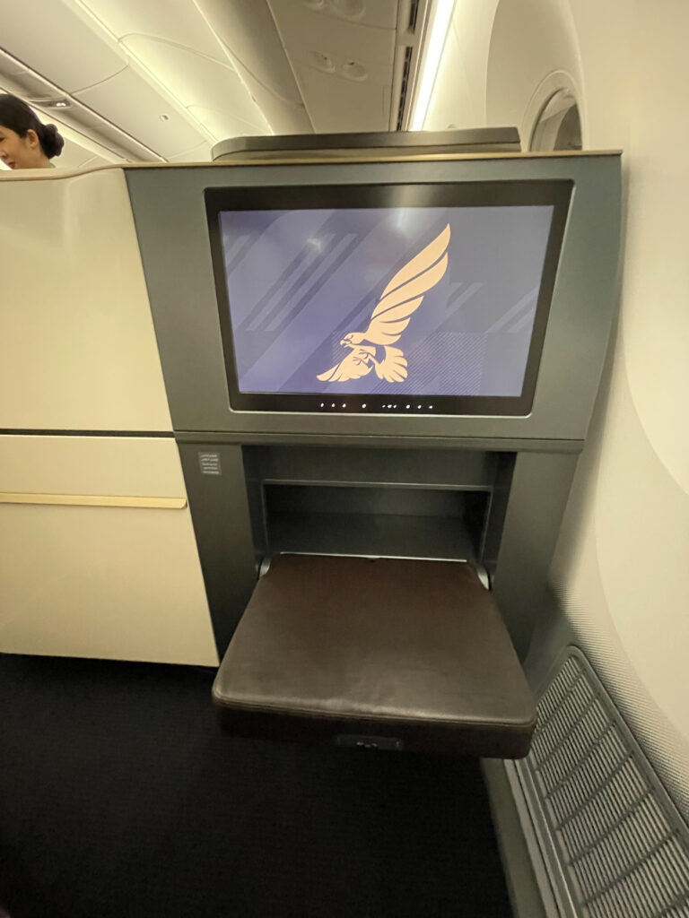 A close up of the IFE screen and ottoman in the business class seat on the Gulf Air Boeing 787-9