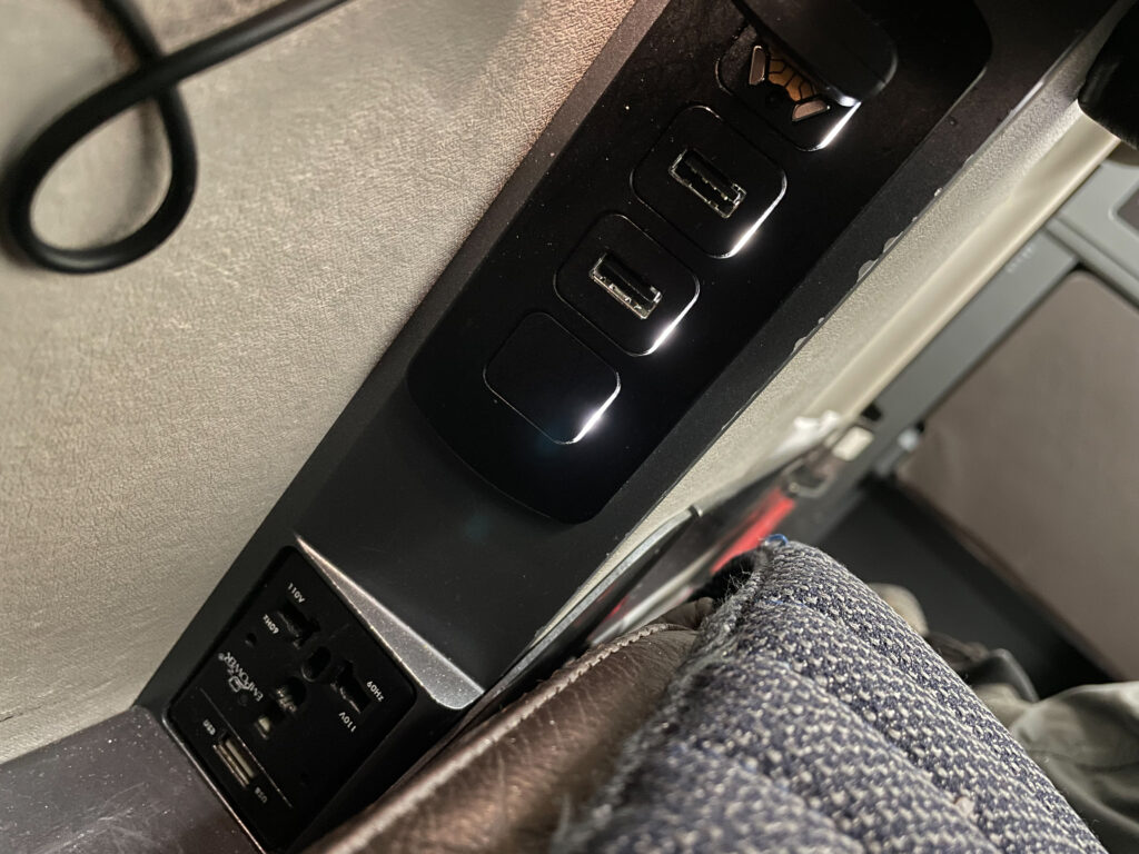 USB and AC charging ports in the business class seat.