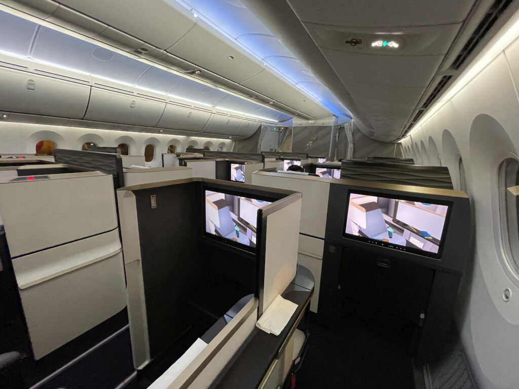 The Gulf Air Business Class seat on the Boeing 787-9 with cream thermoplastics surrounding it and black details.