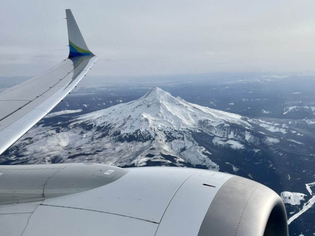 Looking out the window of the Alaska Airlines' Boeing 737-9 over snowy mountains. 