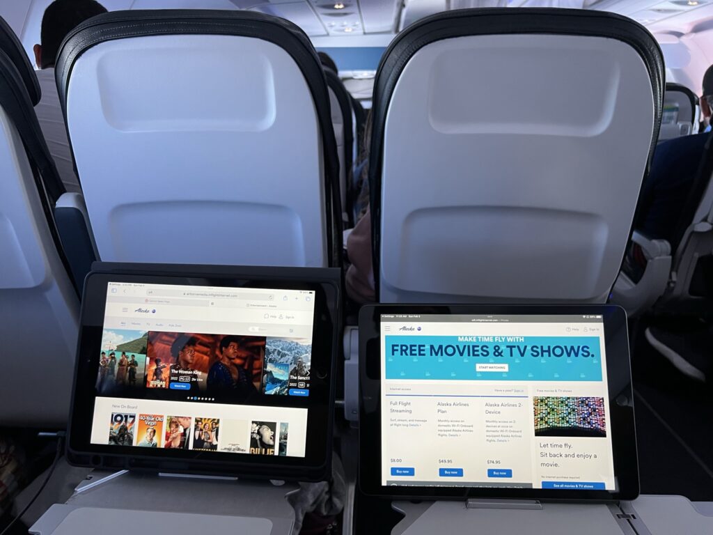 The author's device is positioned on the tray table device holder in the exit row.