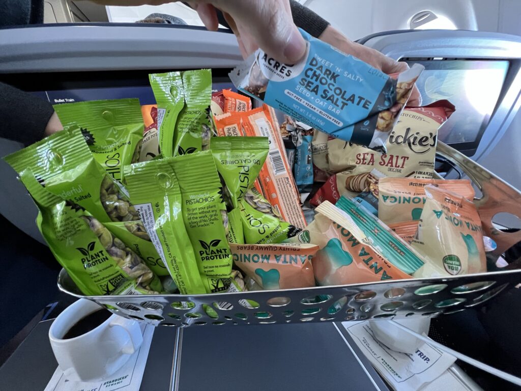 A basket of assorted packaged snacks offered on the Delta flight. 