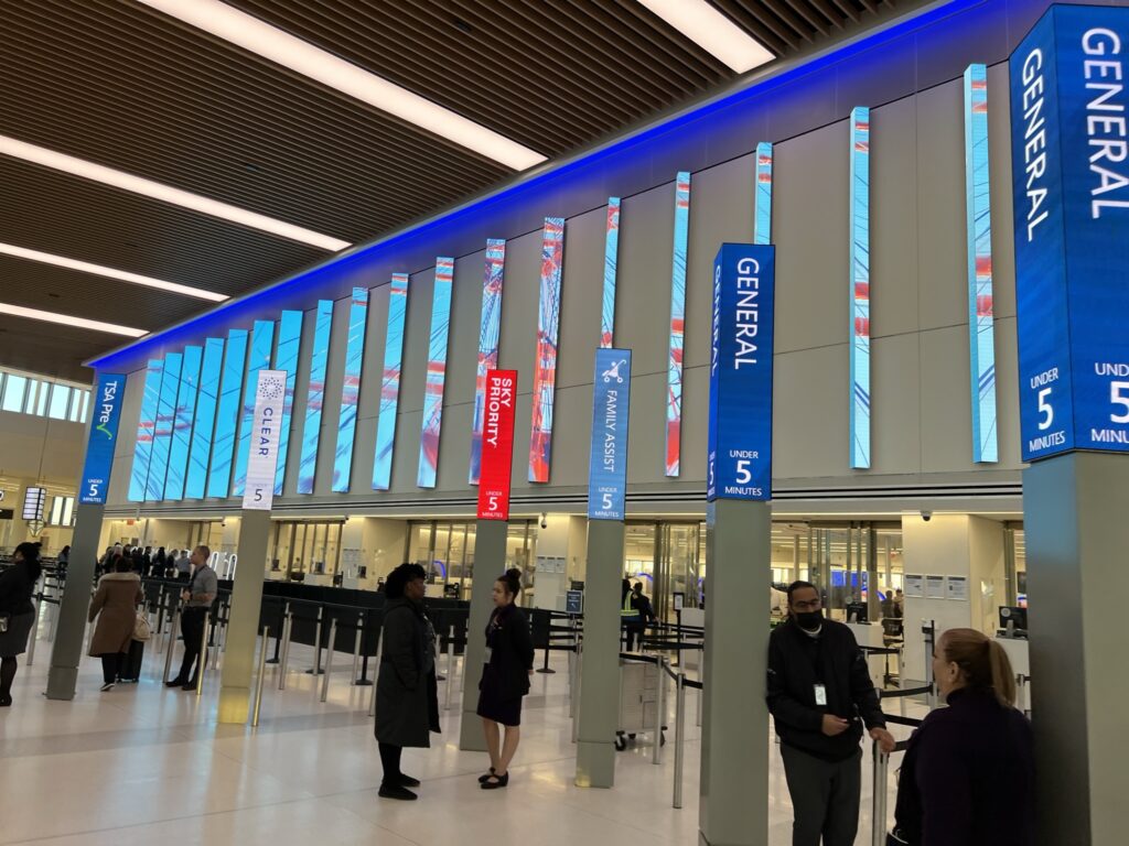 LaGuardia Airport TSA checkpoint, flanked by decorative digital signage 