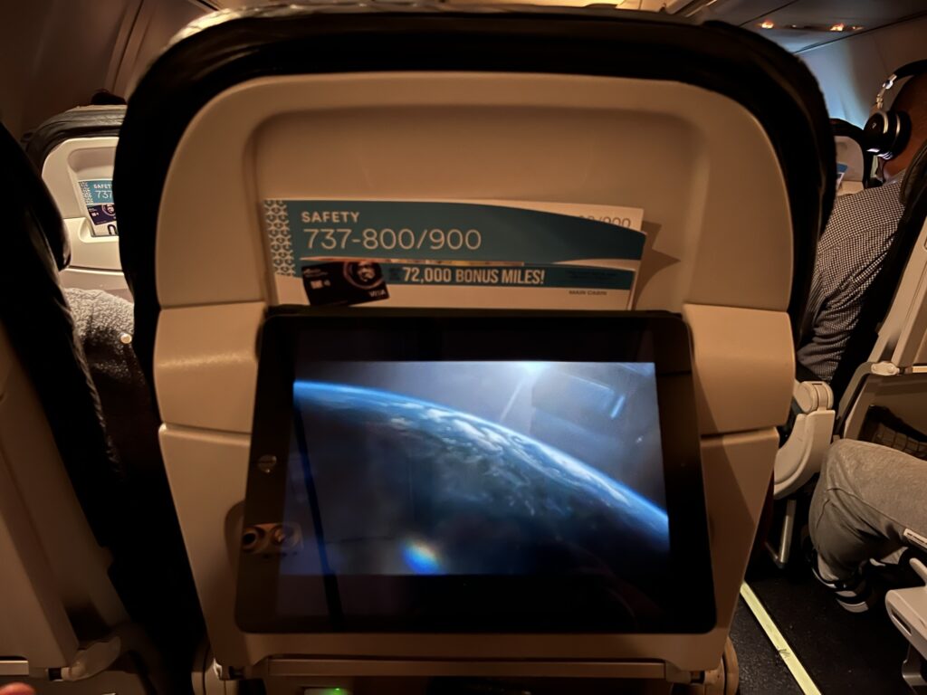 An iPad is being held up on the aircraft by tucking the case into the literature pocket.