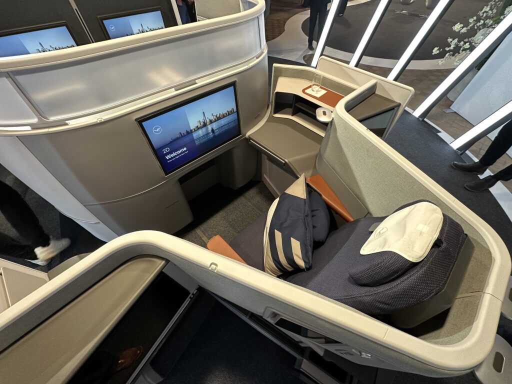 Overhead view of the Extra Long Bed seat in blue. A striped pillow seats atop it.