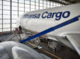 A Lufthansa Cargo 777 aircraft, with AeroSHARK film, is parked in the hanger.