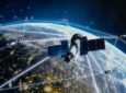 A satellite is in orbit over the earth. The Gilat logo is in the top left corner. Working with SES
